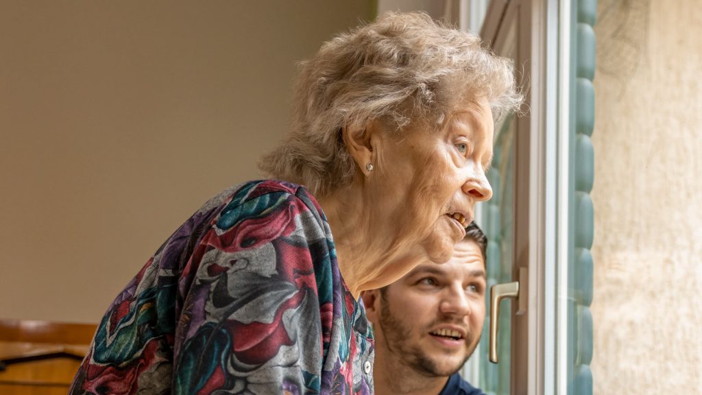 Stiftung Hospital St. Cyriaci et Antonii – Seniorin und Pfleger am Fenster